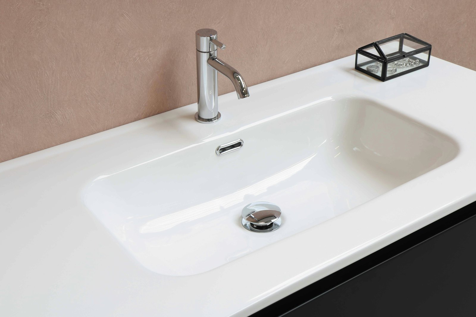 A new chrome faucet on a white bathroom basin
